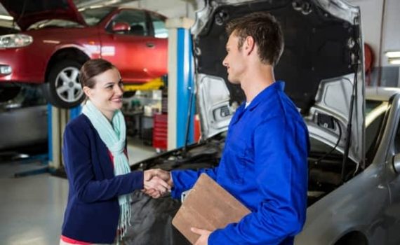 A happy customer shaking hands with the mechanic